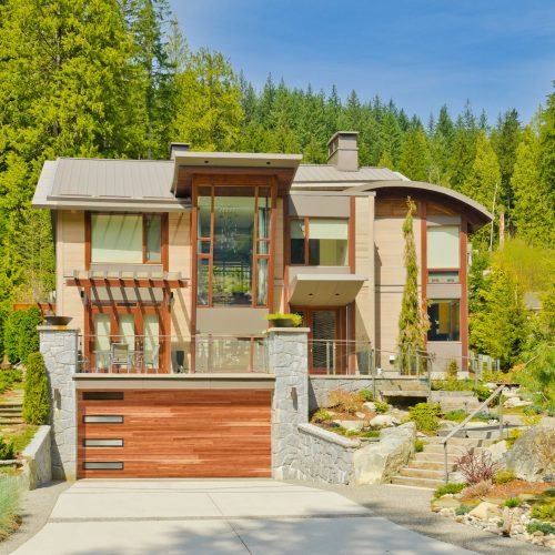 Big custom made luxury house on the rocky slope with nicely landscaped front yard in the suburbs of North Vancouver, Canada.